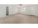 Bright living room featuring neutral carpet, a ceiling fan, and a window overlooking the front yard at 1817 W Claremont St, Phoenix, AZ 85015