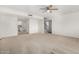 Spacious living area with carpet, leading to the updated kitchen and stairs to the second floor at 1817 W Claremont St, Phoenix, AZ 85015