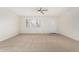 Bright living room featuring neutral carpet, a ceiling fan, and a window overlooking the front yard at 1817 W Claremont St, Phoenix, AZ 85015