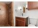 Bathroom with tiled shower, wood vanity, white countertop, and modern fixtures at 1824 W State Ave, Phoenix, AZ 85021