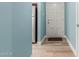 Hallway with stainless steel refrigerator, light wood-look flooring and a white entry door at 1824 W State Ave, Phoenix, AZ 85021