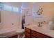 Well-lit bathroom with a single vanity, shower-tub, and decorative wall art at 18259 W Buena Vista Dr, Surprise, AZ 85374