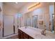 Bathroom featuring a double vanity, large mirror, and walk-in shower at 18259 W Buena Vista Dr, Surprise, AZ 85374