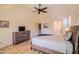 Bedroom with a ceiling fan, ensuite bathroom, and wood dresser with TV at 18259 W Buena Vista Dr, Surprise, AZ 85374