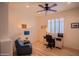 Cozy bedroom featuring wood floors, ceiling fan, shuttered window, desk and chair, and leather sofa at 18259 W Buena Vista Dr, Surprise, AZ 85374