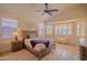 Bright bedroom with a ceiling fan, natural light, shuttered windows, and wood laminate floors at 18259 W Buena Vista Dr, Surprise, AZ 85374