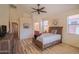 Bedroom with a ceiling fan, wood dresser, and an ensuite bathroom at 18259 W Buena Vista Dr, Surprise, AZ 85374