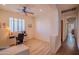 Bedroom showing wood floors, a desk, a ceiling fan, and a shuttered window at 18259 W Buena Vista Dr, Surprise, AZ 85374