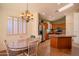 Charming dining area with a skylight and backyard views, featuring a decorative chandelier and a neutral color palette at 18259 W Buena Vista Dr, Surprise, AZ 85374