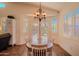 Bright dining space with backyard access and views, featuring a traditional chandelier and an oval table with seating for four at 18259 W Buena Vista Dr, Surprise, AZ 85374