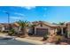 View of the home's front exterior, highlighting the desert landscaping, paver driveway, and two-car garage at 18259 W Buena Vista Dr, Surprise, AZ 85374