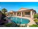 Backyard view of sparkling pool, covered patio, desert landscaping, and outdoor seating area for relaxing and entertaining at 18259 W Buena Vista Dr, Surprise, AZ 85374