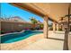 Inviting backyard pool with a covered patio, palm tree and blue water provides a tranquil and relaxing outdoor space at 18259 W Buena Vista Dr, Surprise, AZ 85374