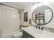 Well-lit bathroom featuring shower/tub combo, a round mirror, and decorative shelves at 1849 E 2Nd Pl, Mesa, AZ 85203