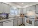 Well-lit kitchen featuring white appliances, granite countertops, and ample cabinet space at 1849 E 2Nd Pl, Mesa, AZ 85203