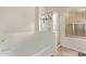 A bright bathroom featuring a bathtub, a glass-enclosed shower, and a window providing natural light at 18537 W Mariposa Dr, Surprise, AZ 85374