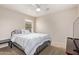 A comfortable bedroom featuring a cozy bed, a ceiling fan, and a window for natural light at 18537 W Mariposa Dr, Surprise, AZ 85374