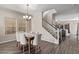 Inviting dining area with a stylish chandelier, wood floors, and staircase to the upper level at 18537 W Mariposa Dr, Surprise, AZ 85374