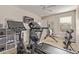 A home gym featuring a treadmill, exercise bike, weights, and shelving for organized workouts at 18537 W Mariposa Dr, Surprise, AZ 85374