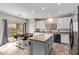 Well-lit kitchen featuring white cabinets, tile backsplash, stainless steel appliances, an island, and an eat-in dining area at 18537 W Mariposa Dr, Surprise, AZ 85374