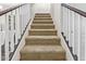 Carpeted staircase with white banister and dark wood railing leads to the upper level of this inviting home at 18537 W Mariposa Dr, Surprise, AZ 85374