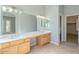 This bathroom features a dual sink vanity, large mirror, and neutral-colored tile flooring at 19861 S 191St St, Queen Creek, AZ 85142