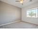 This bedroom features a neutral color palette, ceiling fan, and a large window providing ample natural light at 19861 S 191St St, Queen Creek, AZ 85142