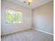 This bedroom has carpeted floors, a ceiling fan, and a large window with views of lush greenery at 19861 S 191St St, Queen Creek, AZ 85142