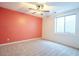 Bedroom featuring a ceiling fan, neutral carpet, and an orange accent wall at 19861 S 191St St, Queen Creek, AZ 85142