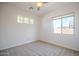 The carpeted bedroom has a ceiling fan and offers natural light through two separate window styles at 19861 S 191St St, Queen Creek, AZ 85142