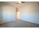 This bedroom offers carpeted floors, closet with white bi-fold doors, a ceiling fan, and access to additional rooms at 19861 S 191St St, Queen Creek, AZ 85142