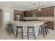 Spacious kitchen featuring dark wood cabinetry, granite countertops, a center island, and stainless-steel appliances at 19861 S 191St St, Queen Creek, AZ 85142