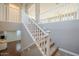 A staircase with white railings leads to the second story, overlooking the living area at 19861 S 191St St, Queen Creek, AZ 85142