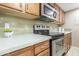 Close up on kitchen appliances and cabinets showing stainless steel microwave and oven at 200 E Southern Ave # 173, Tempe, AZ 85282