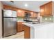 Well-lit kitchen with stainless steel appliances, wood cabinets, and white quartz countertops at 200 E Southern Ave # 173, Tempe, AZ 85282