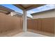 View of the backyard with block wall, concrete patio, and a column supporting the patio roof at 20318 W Turney Ave, Buckeye, AZ 85396