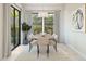 Elegant dining room with a modern chandelier, a wooden table, and chairs and large windows with backyard views at 20318 W Turney Ave, Buckeye, AZ 85396