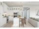 Open-concept kitchen with white cabinetry, island seating, stainless steel appliances, and seamless connection to the living area at 20318 W Turney Ave, Buckeye, AZ 85396