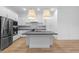 Modern kitchen featuring a center island, stainless steel appliances, white cabinetry, and wood-look tile flooring at 20318 W Turney Ave, Buckeye, AZ 85396