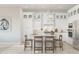 Bright white kitchen featuring a large island with barstool seating and pendant lighting and stainless steel appliances at 20318 W Turney Ave, Buckeye, AZ 85396