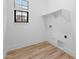 Bright laundry room with modern flooring, a window, and a shelf above washer/dryer hookups at 20318 W Turney Ave, Buckeye, AZ 85396