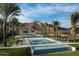 Lush pool area with palm trees, modern lounge chairs, and stunning mountain views for ultimate relaxation at 20318 W Turney Ave, Buckeye, AZ 85396