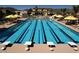 Well-maintained swimming pool with lane dividers, starting blocks, and umbrellas for a relaxing experience at 20318 W Turney Ave, Buckeye, AZ 85396