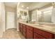 Well-lit bathroom featuring a dual sink vanity, a large mirror, and a glass-enclosed shower stall at 21362 N 260Th Ln, Buckeye, AZ 85396