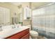 Cozy bathroom with wood vanity, bright sink, decorative mirror, and patterned shower curtain at 21362 N 260Th Ln, Buckeye, AZ 85396