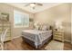 Inviting bedroom features wood-look floors, a ceiling fan, a neutral color scheme, and a comfortable bed at 21362 N 260Th Ln, Buckeye, AZ 85396