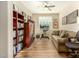 Cozy living room with wood-look floors, a comfortable sofa, bookshelves, and natural light at 21362 N 260Th Ln, Buckeye, AZ 85396