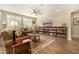 Inviting living room with a ceiling fan, wood floors, and a large bookcase at 21362 N 260Th Ln, Buckeye, AZ 85396