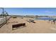 Sandy picnic area by a pond, featuring picnic tables and shade structures for residents to enjoy at 2401 E Spur Dr, San Tan Valley, AZ 85140