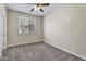 Cozy bedroom with carpet, a ceiling fan, a window with blinds, and neutral paint, creating a serene atmosphere at 2592 E Torrey Pines Ln, Chandler, AZ 85249